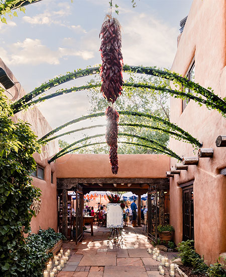 Courtyard with people gathered for an event at The Inn of The Five Graces and Pink Adobe