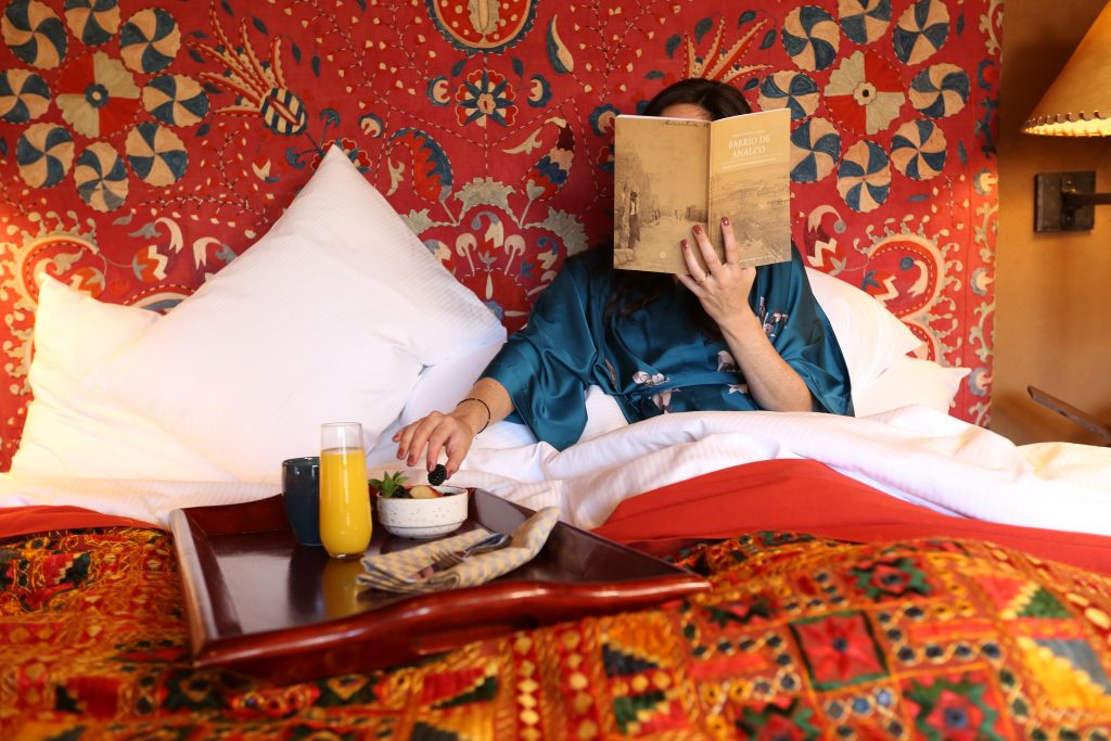 The Inn of The Five Graces Woman Reading enjoying breakfast in bed